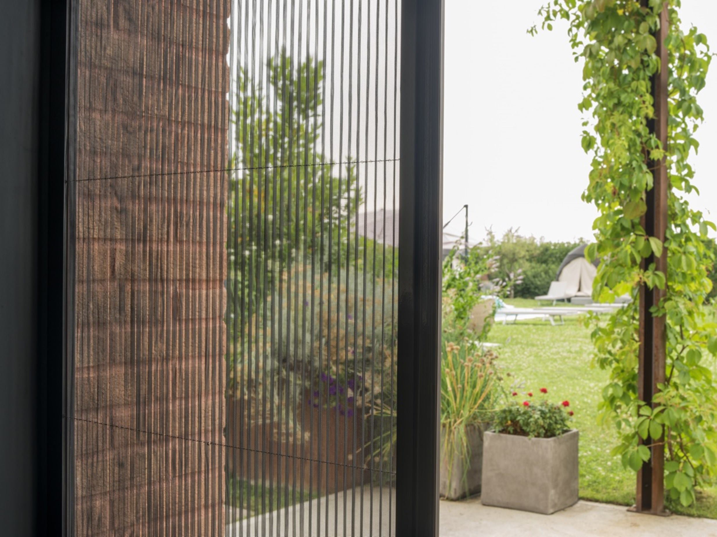 Mosquitera Plisada en una puerta que lleva al jardín de la vivienda 